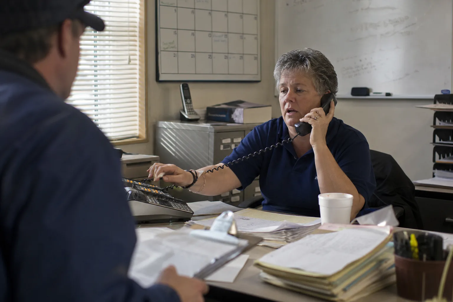 Dispatcher at a US HVAC shop juggling multiple calls on hold, the daily chaos phone routing software solves